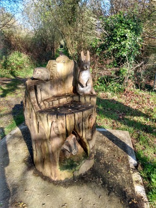 Wood carvings alongside riverbank trail